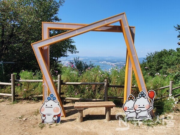 검단산 중턱 포토포인트. 검단산 정상에서 곱돌약수터와 잣나무숲 방향으로 하산하다 보면 중턱에 전망 정자가 있으며 그 옆에 등산객들이 한강변을 배경으로 사진을 찍을 수 있는 포토포인트 액자 조형물이 조성되어 있다. 액자 조형물 앞 벤치에 앉아 한강을 배경으로 사진을 찍다 보면 가을의 한가운데 나도 모르게 풍덩 빠지게 된다.