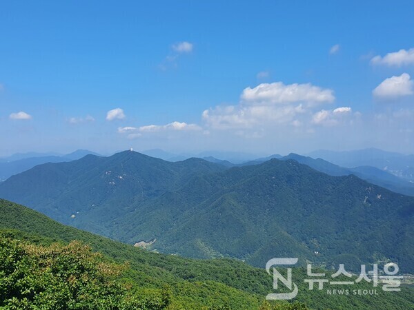 검단산 정상에서 바라본 예봉산과 운길산. 검단산 정상에서는 북쪽방향으로 한강 건너 남양주시 와부읍 팔당리에 있는 ‘예봉산’과 남양주시 조안면에 있는 ‘운길산’이 한눈에 조망된다. 파아란 가을하늘에 뭉게구름이 피어 있고 그 밑에 짙은 녹색의 숲으로 이루어진 산세가 연이어 펼쳐져 있어 장관을 이룬다.