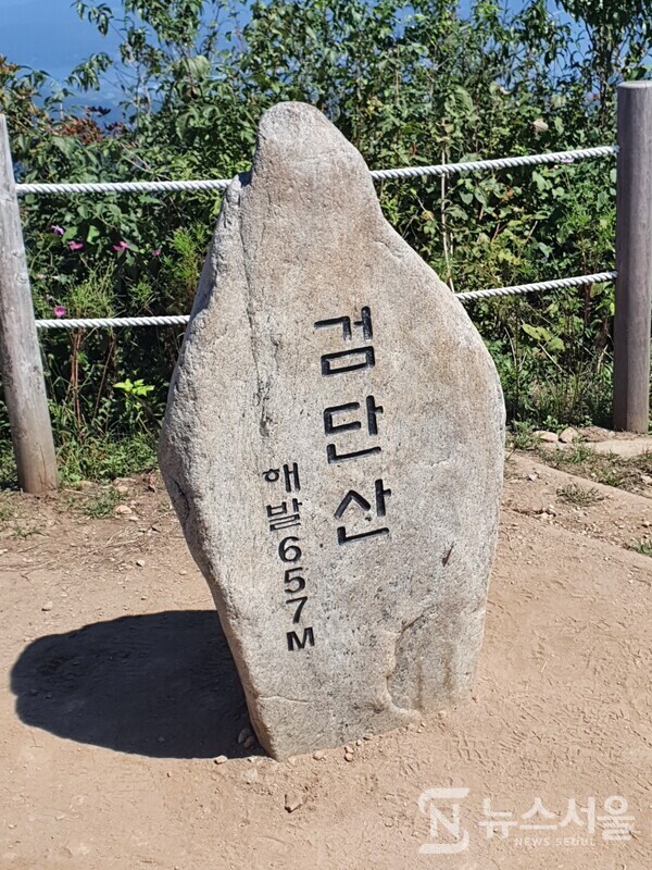 검단산 정상 표지석. 검단산 정상은 해발 657m 높이이다. 검단산 정상에서는 북동쪽으로 남한강과 북한강 물이 합류하는 두물머리(양수리)와 팔당댐이 뚜렷하게 보이고 한강 건너 예봉산 뿐만 아니라 예봉산 정상에 있는 둥근 공 모양의 강우레이더도 한눈에 조망된다