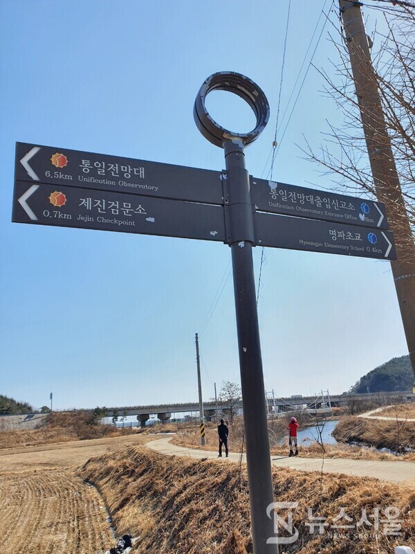 명파리 시골길. 해파랑길 50코스 중 제진검문소에서 남쪽방향으로 도보길을 걷다보면 명파초교와 명파해수욕장으로 나뉘는 갈림길이 나오며 조그만 하천 천변 뚝방길 옆에 낡은 해파랑길 이정표가 서 있다.