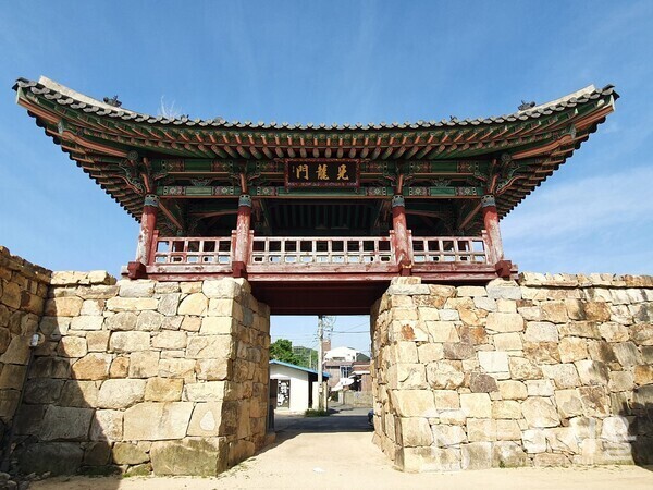 창원 웅천읍성 동문루. 조선 초기 태종 때 왜인들을 통제하면서 교류하기 위해 삼포(三浦)를 개항하고 왜관을 설치할 수 있도록 허락하였는데, ‘삼포(三浦)’는 바로 ‘부산포(釜山浦)’, ‘염포(鹽浦)’, ‘제포(薺浦)’를 말한다. 그 중 ‘제포(薺浦)’는 ‘내이포’라로도 불리웠던 곳으로 현재 창원시 진해구 제덕동 인근 포구로서 제덕만매립지 일대를 말한다. 제포(薺浦)를 개항함으로 인해 항거왜인(恒居倭人)의 세력이 급증하자 이들의 준동을 방비하기 위해 조선 세종 때 ‘웅천읍성’을 축조하였다. ‘웅천읍성’은 19세기 말까지 읍성으로 기능하다가 갑오개혁을 거치면서 읍성으로서의 기능을 상실하게 되었고 현재는 읍성의 상당부분이 훼손되고 일부만이 남아있다. 웅천읍성에는 원래 4개의 대문이 있었는데 현재는 동벽과 동문터만 남아있고 서벽과 남벽은 일부만, 북벽은 흔적도 없는 상태이다 동문루 누각은 복원되어 축조되어 있는데 ‘견룡문(見龍門)’이라는 현판이 걸려있다.